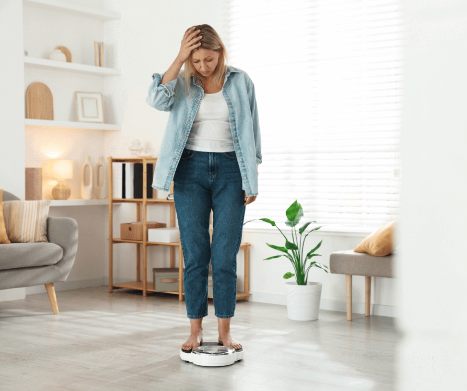 Eine Frau steht auf der Waage und schaut verzweifelt auf das Display.