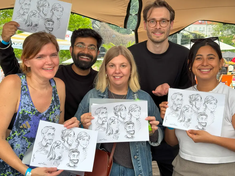 Glückliche Kursteilnehmerinnen halten ihre selbst gezeichneten Portraits in den Händen – Ergebnis der Portrait-Ausbildung