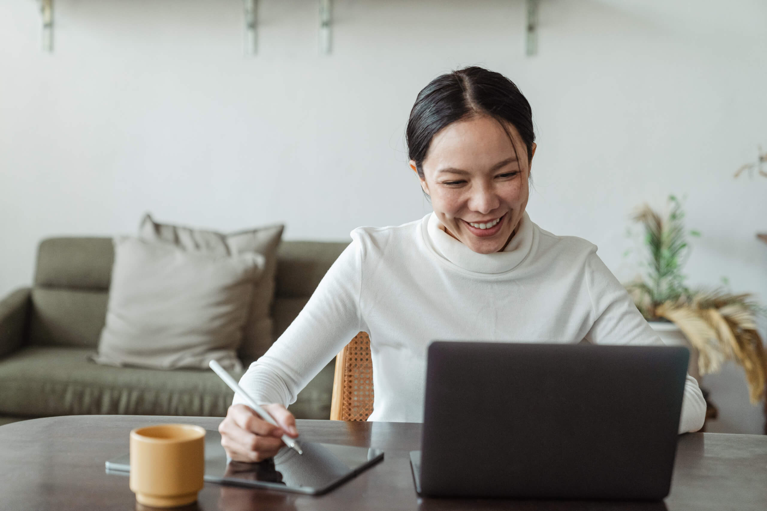 Happy woman working at home on laptop