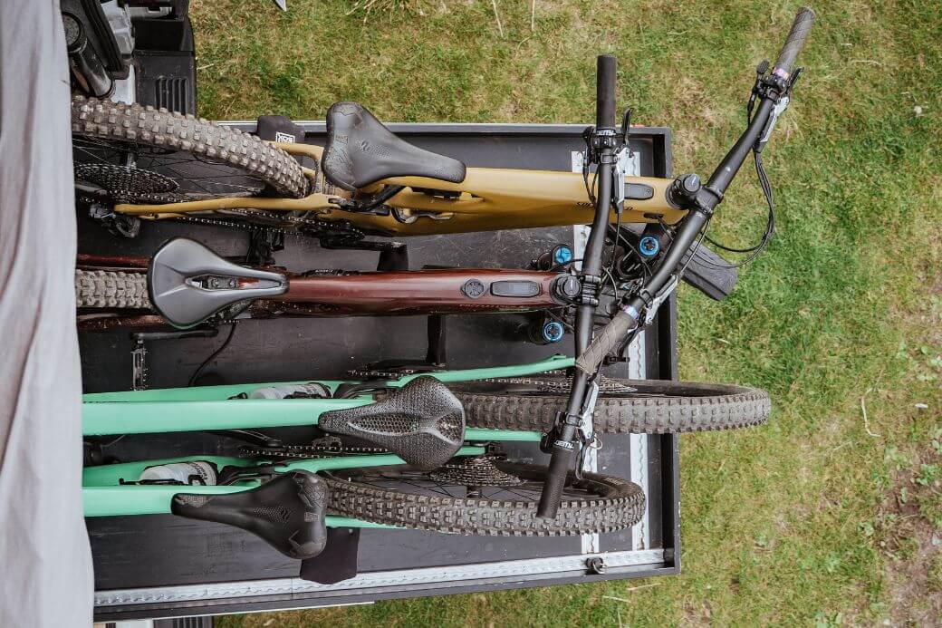 Draufsicht: vier Mountainbikes nebeneinander auf Heckauszug im Camper