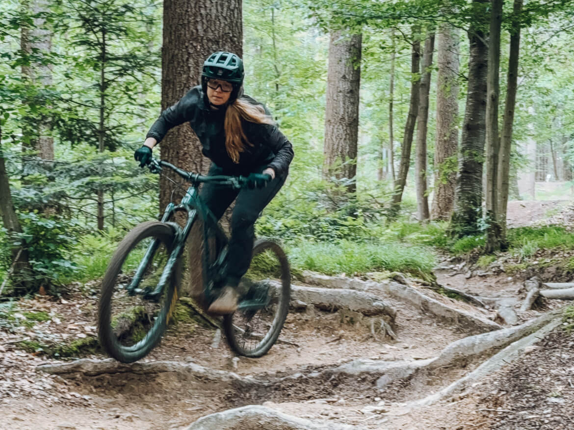 Mountainbikerin fährt auf Freiburger Endurotrail über Wurzeln