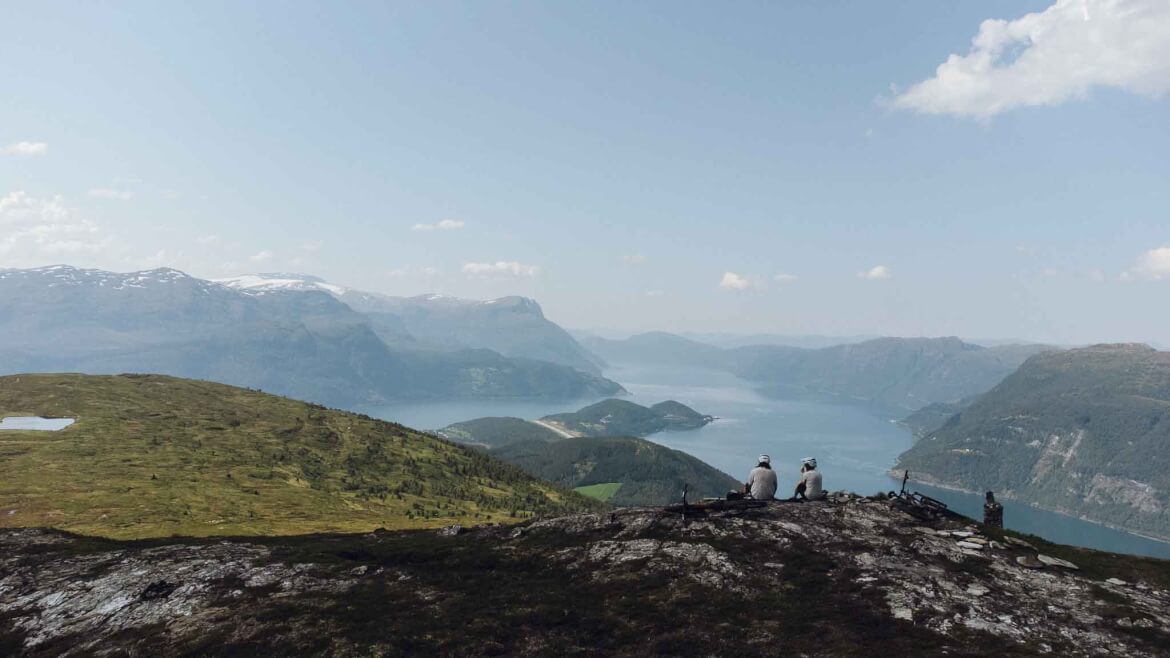 Claudia und Roman von BUCKETRIDE genießen den epischen Fjordblick in Norwegen auf ihrem Mountainbike Roadtrip durch Europa
