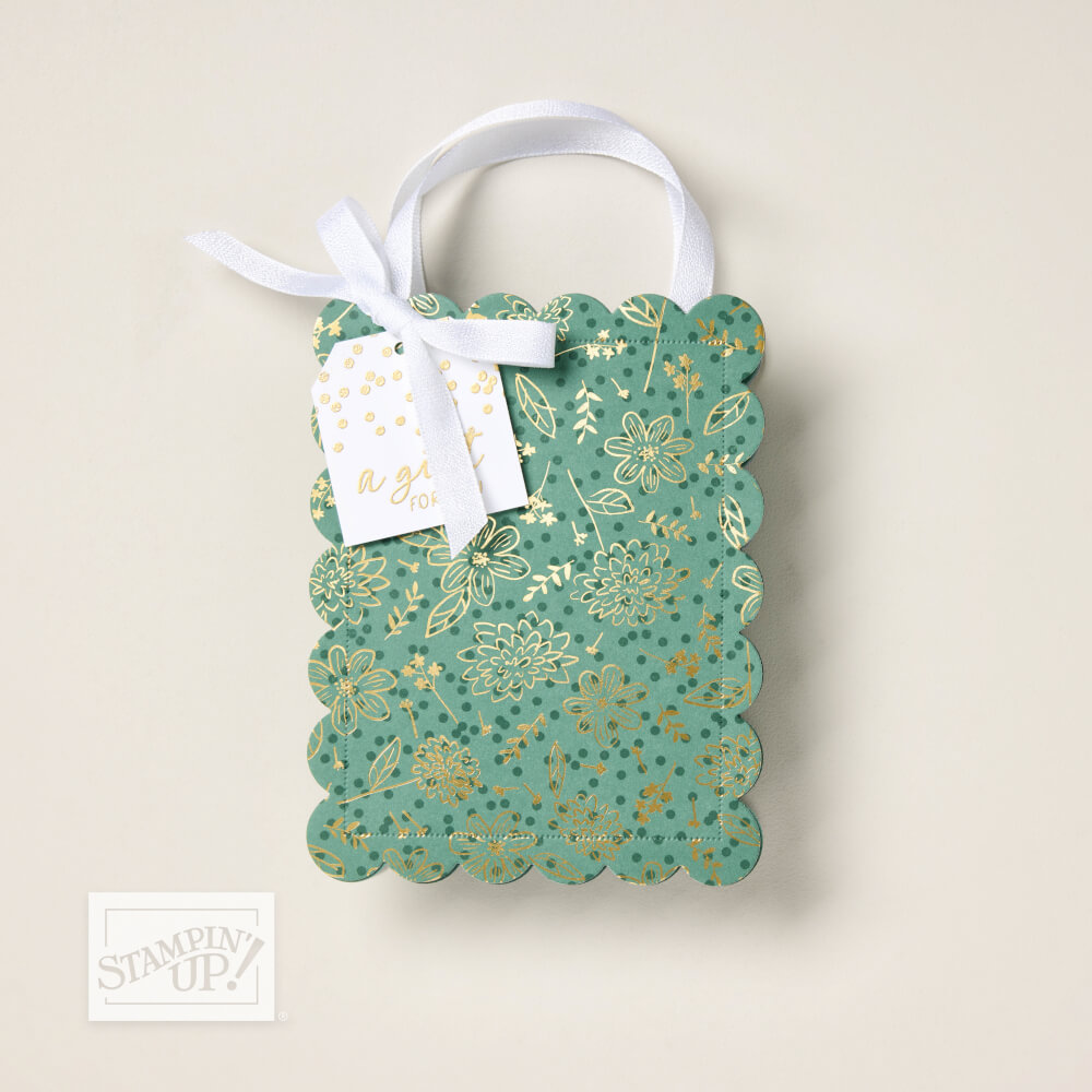 Kleine Geschenktüte aus Designerpapier Blattwerk voller Eleganz in Grün und Gold mit weißem Band und Anhänger