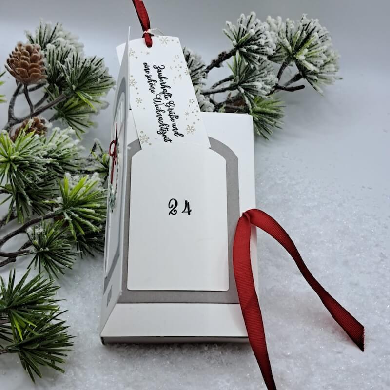 Adventskalender mit herausgezogenem Einsteckfach und rotem Bändchen