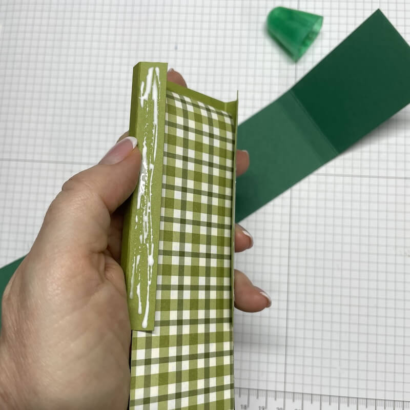 Hand hält die grün karierte Ziehverpackung