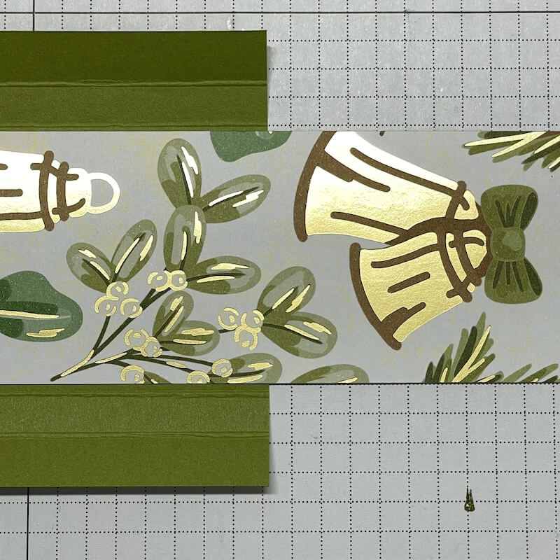 Gold gemusterter Designerpapierstreifen wird in die grüne Hülle geklebt