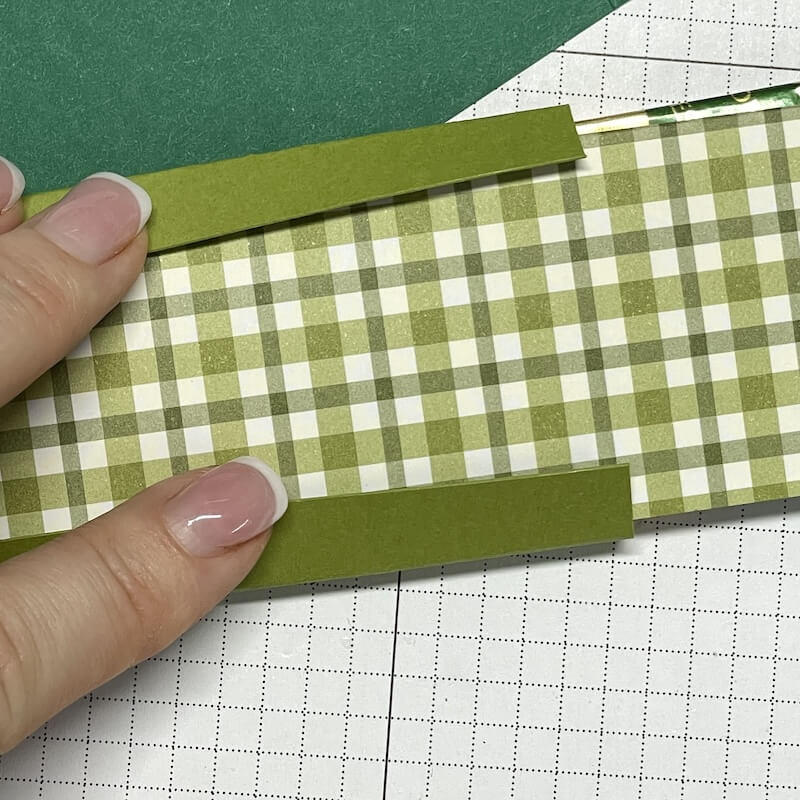 Hände legen den grün karierten Papierstreifen auf die Matte