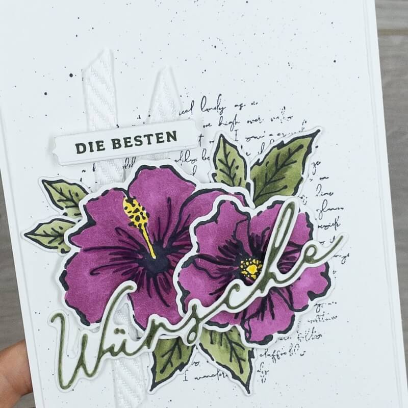 Detail: der ausgestanzte Schriftzug Wünsche liegt über den violetten Blüten