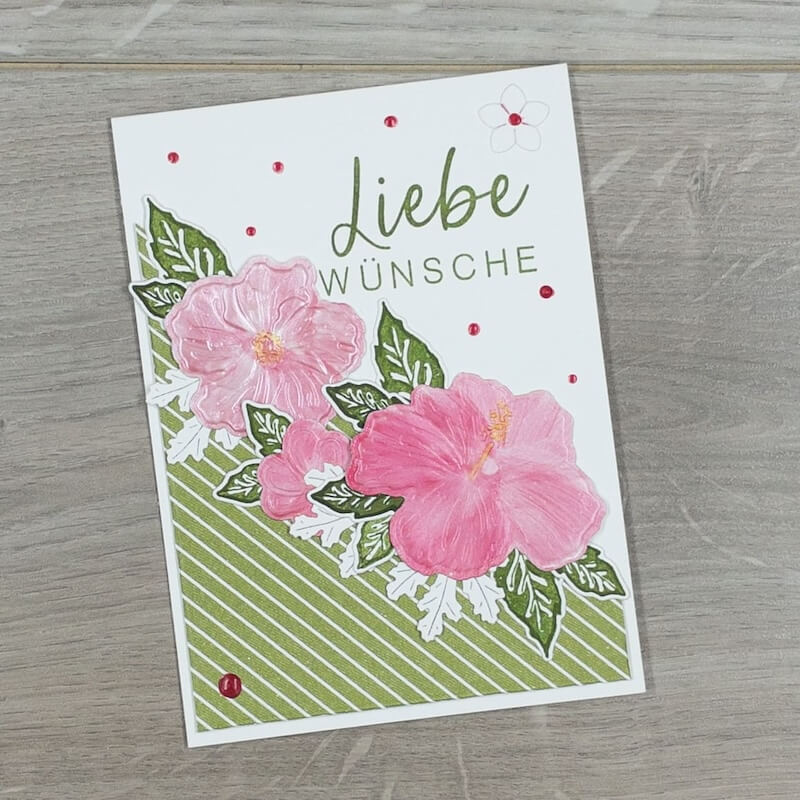 Karte Liebe Wünsche mit zwei rosa Hibiskusblüten auf grün gestreiftem Papier
