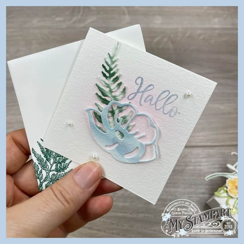 Hand hält eine Karte mit Blüte, Farnwedel und Hallo-Schriftzug aus dem Stampin’ Up! Kartenset