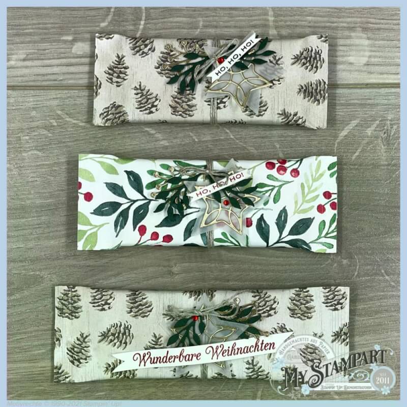 Drei fertige Verpackungen mit verschiedenen Papieren und Weihnachtssprüchen