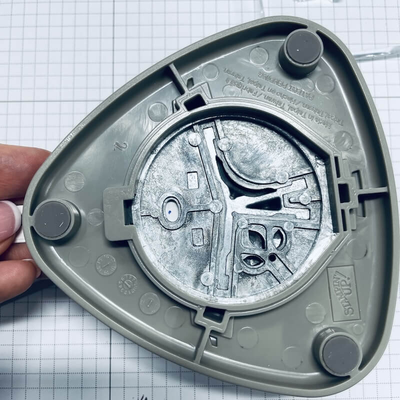 Unterseite der dreieckigen Stampin' Up! Stanze mit sichtbarem Stanzmechanismus in der Hand