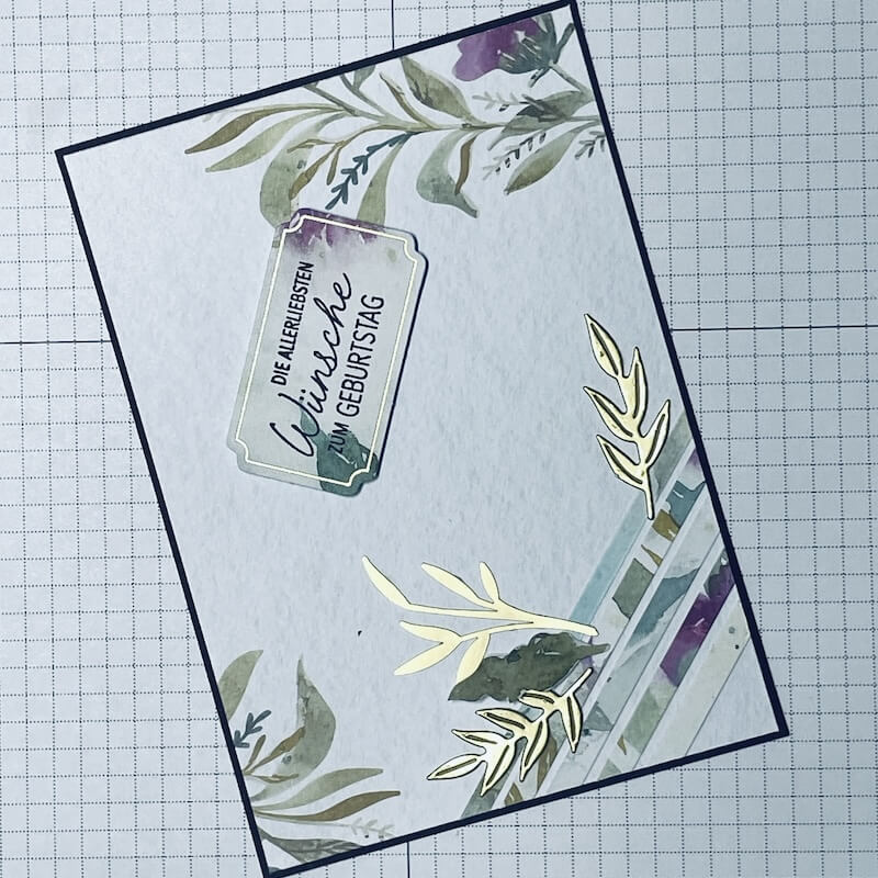 Karte in Arbeit auf der Schneidematte mit floralen Ecken und Spruch-Etikett