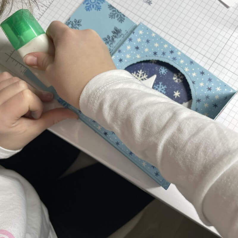 Kleber wird auf die Falzlinie der letzten Seite aufgetragen