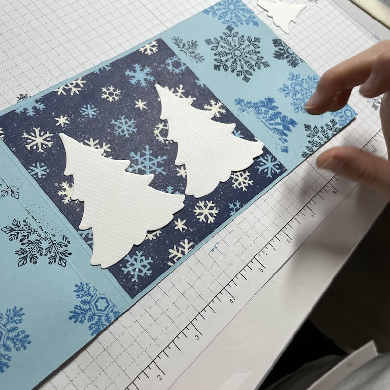 Weiße Tannenbäume im Ausschnitt arrangiert, teils mit Dimensionals aufgeklebt