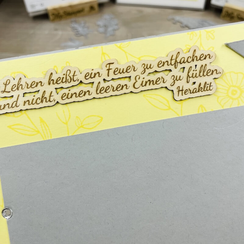 Karteninneres: gelasertes Zitat auf einem gelb bedruckten Streifen über Farbkarton in Schiefergrau