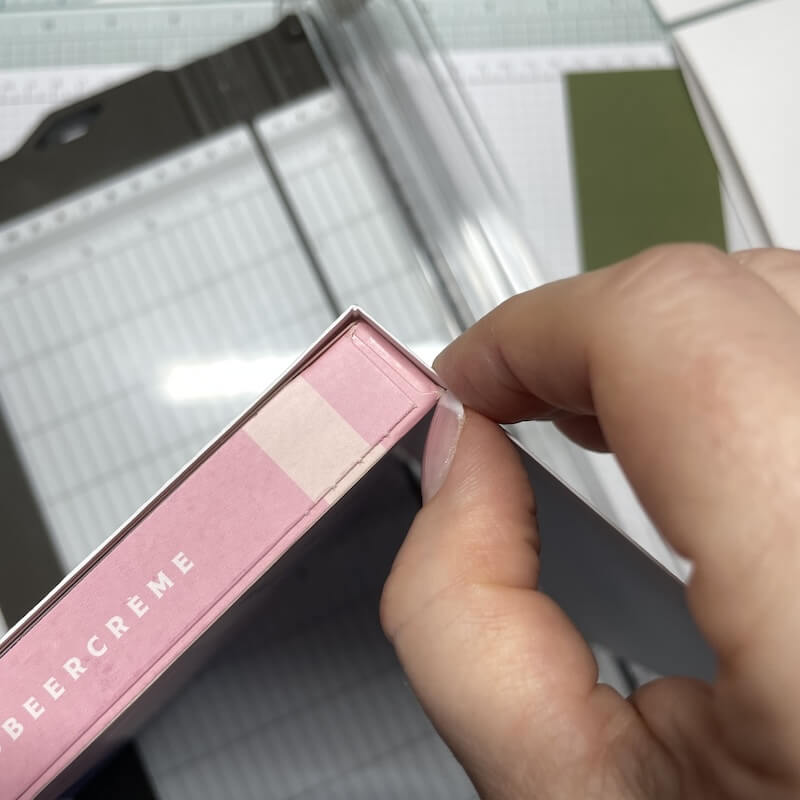 Die Falzlinie wird direkt an der rosa Pralinenschachtel abgemessen