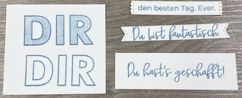 Stempelproben: der Gruß DIR als Umriss und gefüllt, daneben feine Schriftsprüche in Blau
