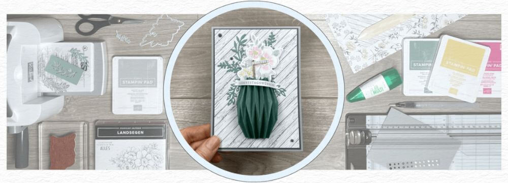 Geburtstagskarte mit gefalteter Papiervase und Blüten in der Hand, drumherum Stempel, Stempelkissen und Werkzeug von Stampin’ Up!