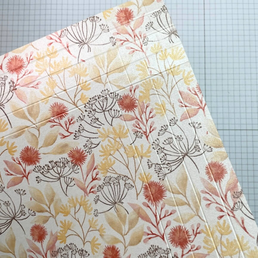 Designerpapier mit gefalzten Linien auf der Schneidematte für die Rahmenbox