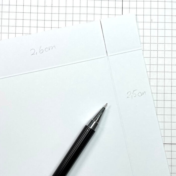Rückseite des Deckelpapiers mit angeschriebenen Maßen 2,6 cm und 2,5 cm und gefalzten Linien