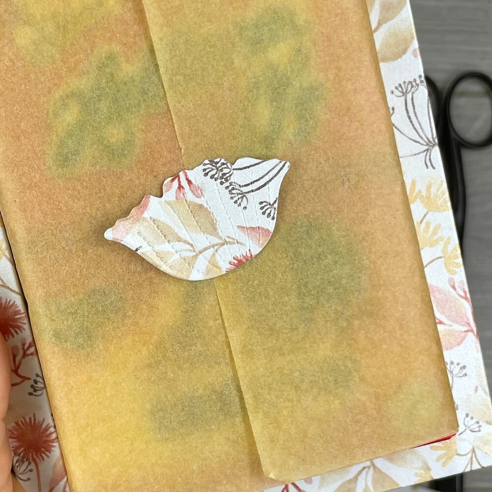 Blick in die Box: Die Packung Hallorenkugeln ist in naturfarbenes Seidenpapier gewickelt und mit einer gestanzten Blüte beklebt