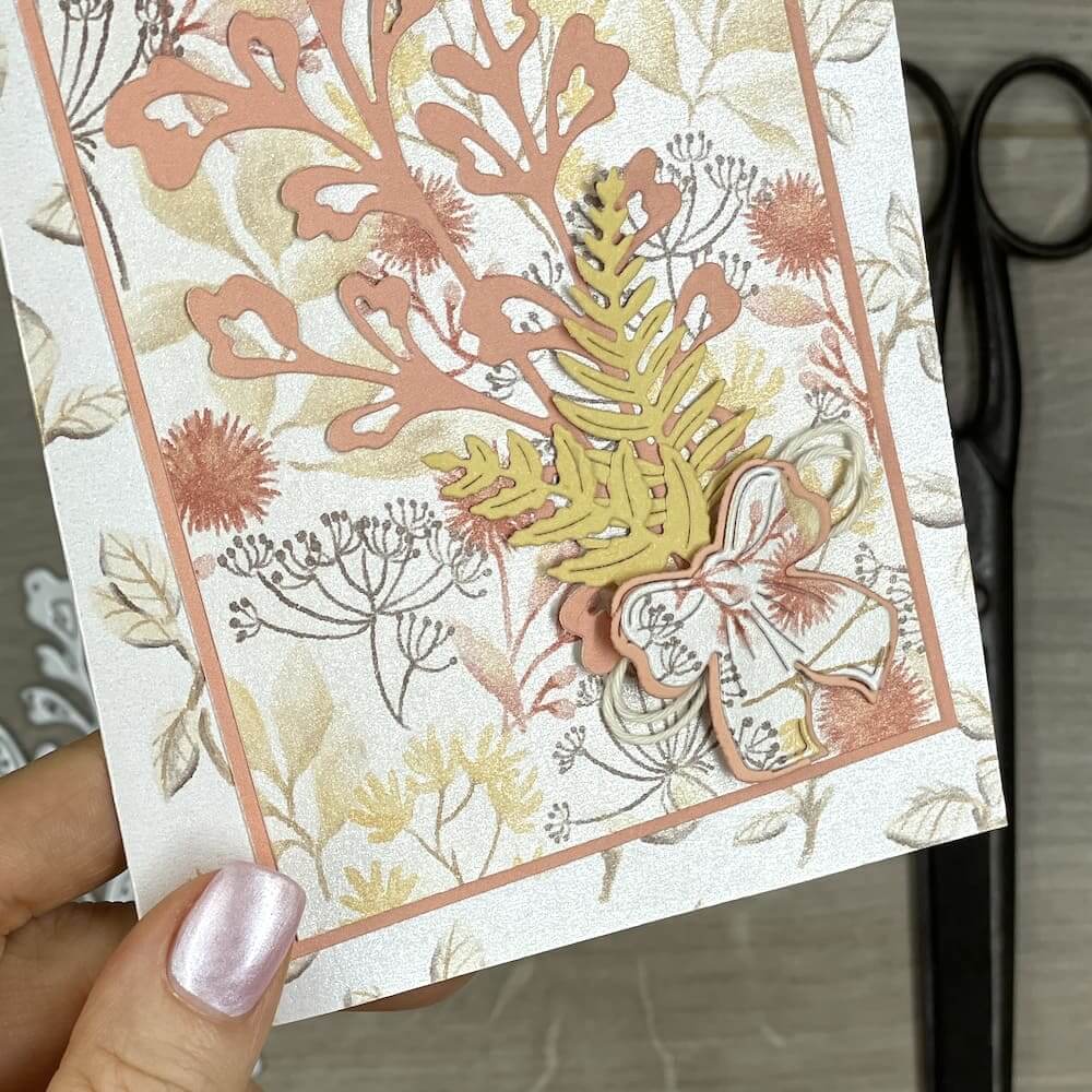 Fertige Gutscheinkarte von außen mit floralem Motiv, Farnen, Schleife und Kordel