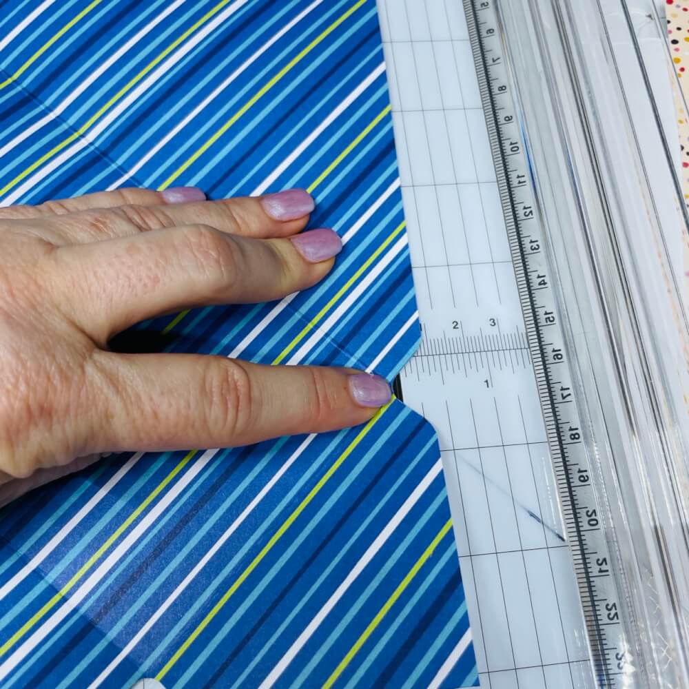 Seitliche Klappe wird im Papierschneider knapp an der Schneiderille gekürzt