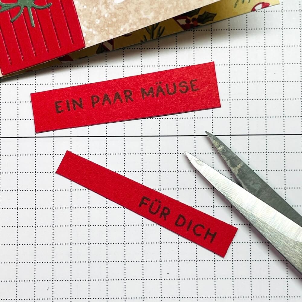 Geprägter Geschenkestapel in Glutrot und der gestempelte Spruchstreifen Ein paar Mäuse für Karte 3