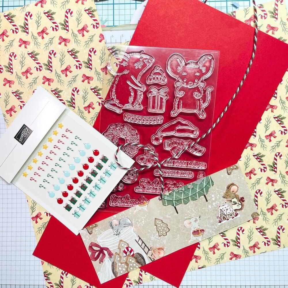 Material für Karte 3: Designerpapier mit Zuckerstangen, glutroter Farbkarton, Stempelset mit Mäusen, Accessoires und Bäckergarn