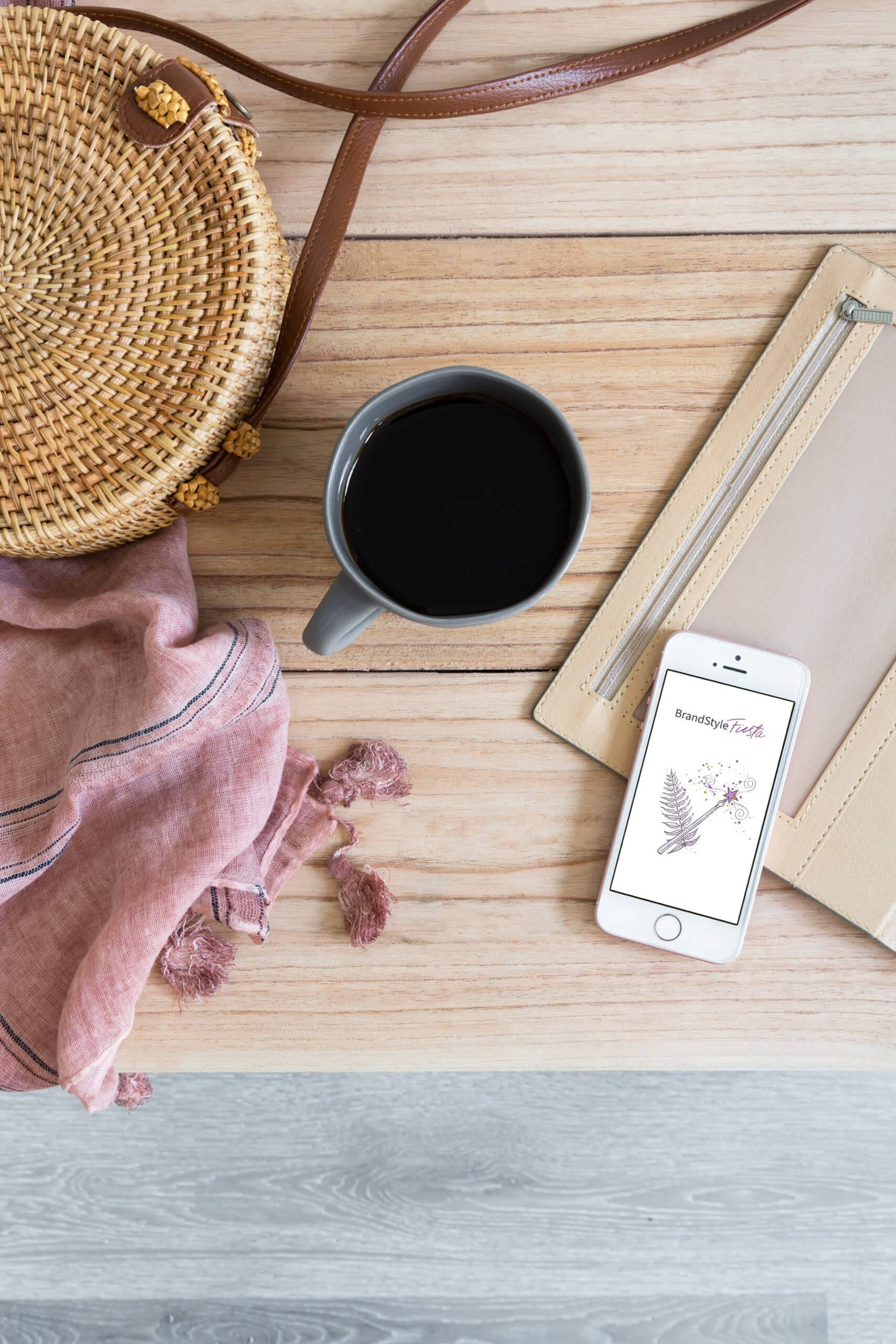 Flatlay mit Kaffeetasse, Tuch und Strohtasche, BrandStyle Fiesta-Logo auf Handy-Display