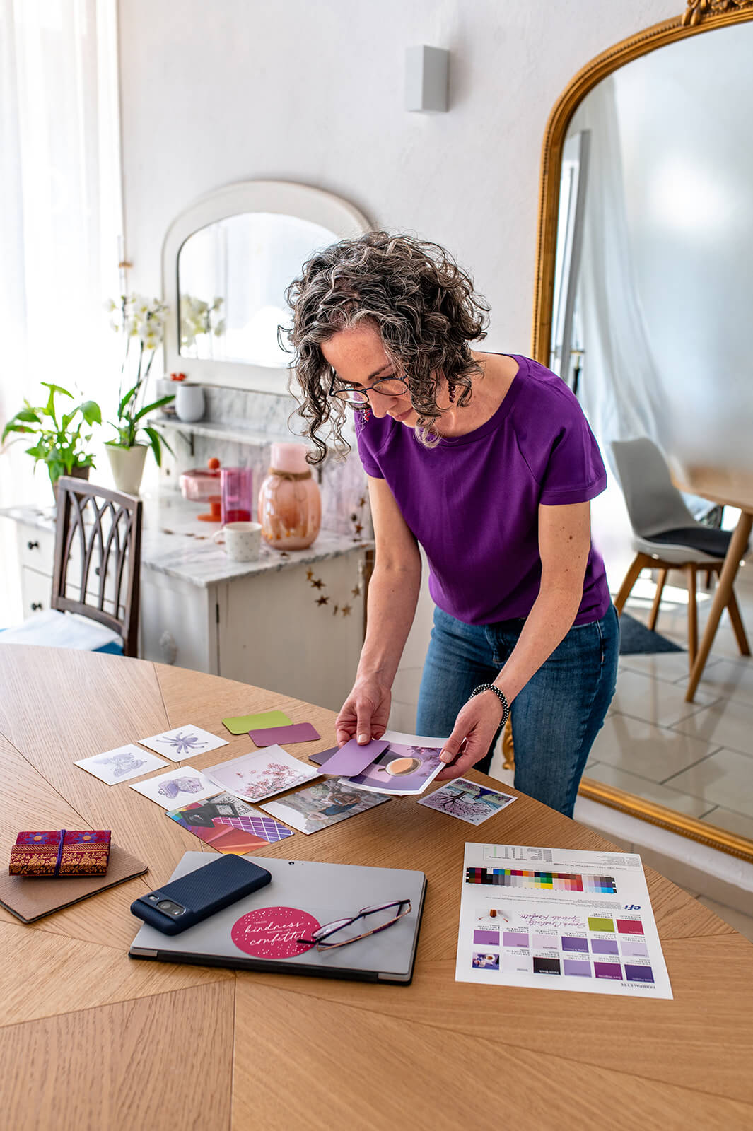 Designerin ordnet Farbproben und Bildmaterial für die Neuausrichtung eines Markenauftritts.