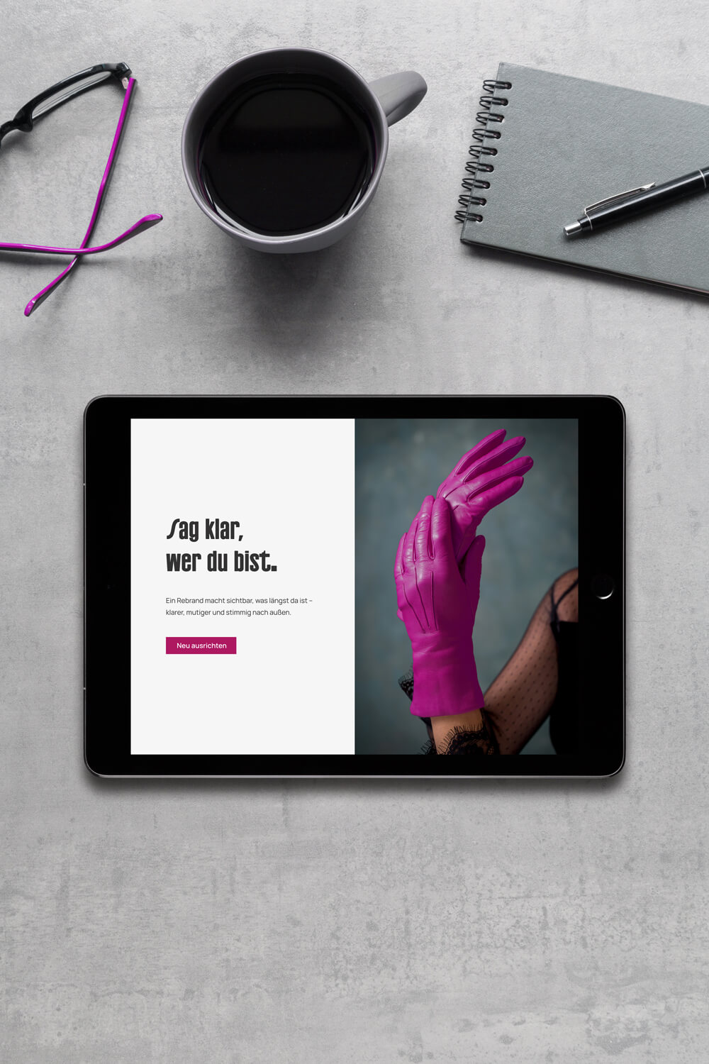 Tablet-Mockup mit Website-Startseite eines Rebrandings, kombiniert aus klarer Typografie und magentafarbenem Editorial-Bild.