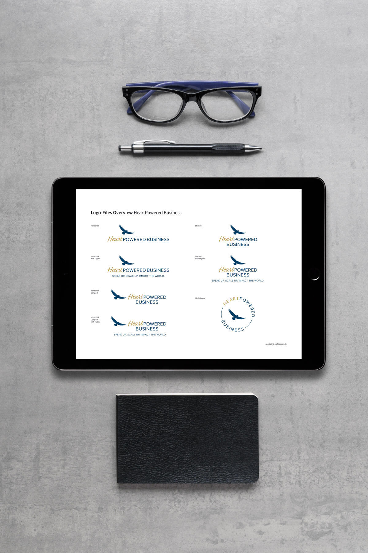 Logo von HeratPowered auf einer Karte in einem Umschlag, in den Händen gehalten über einem Tisch