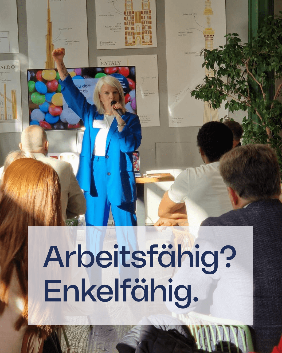 Silke in blauem Anzug bei einem Vortrag vor Publikum. Im Bild steht der Text „Arbeitsfähig? Enkelfähig.“
