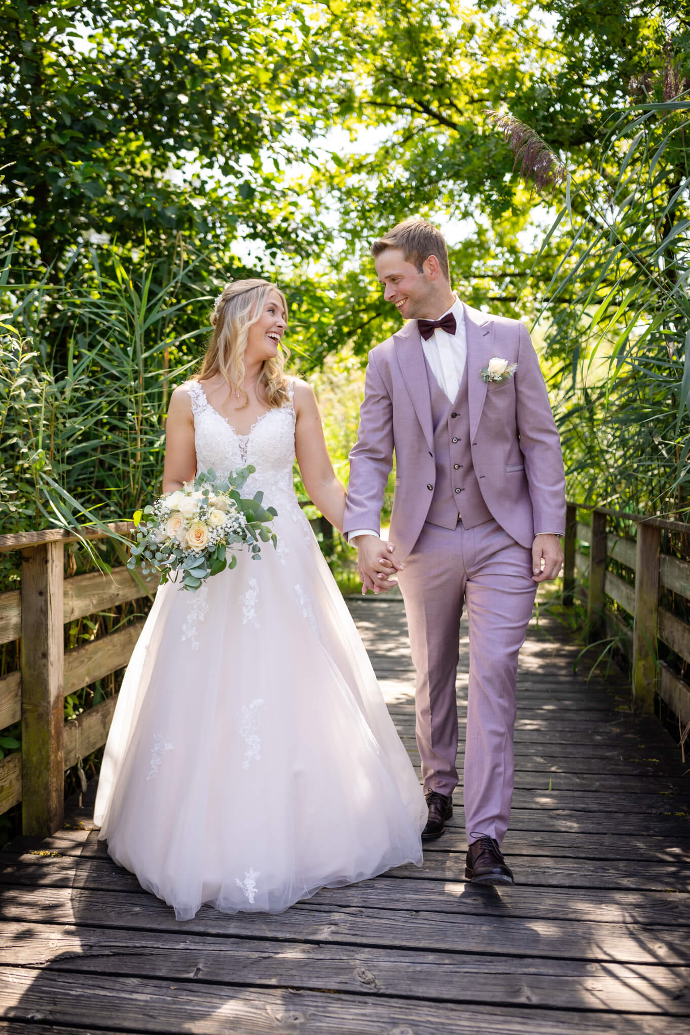 man in black suit kissing woman in white wedding dress