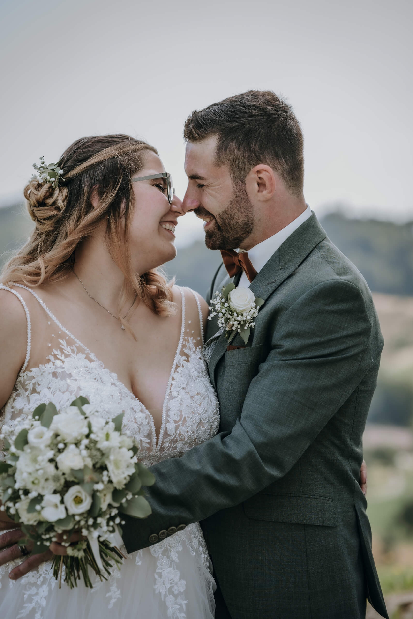man in black suit kissing woman in white wedding dress