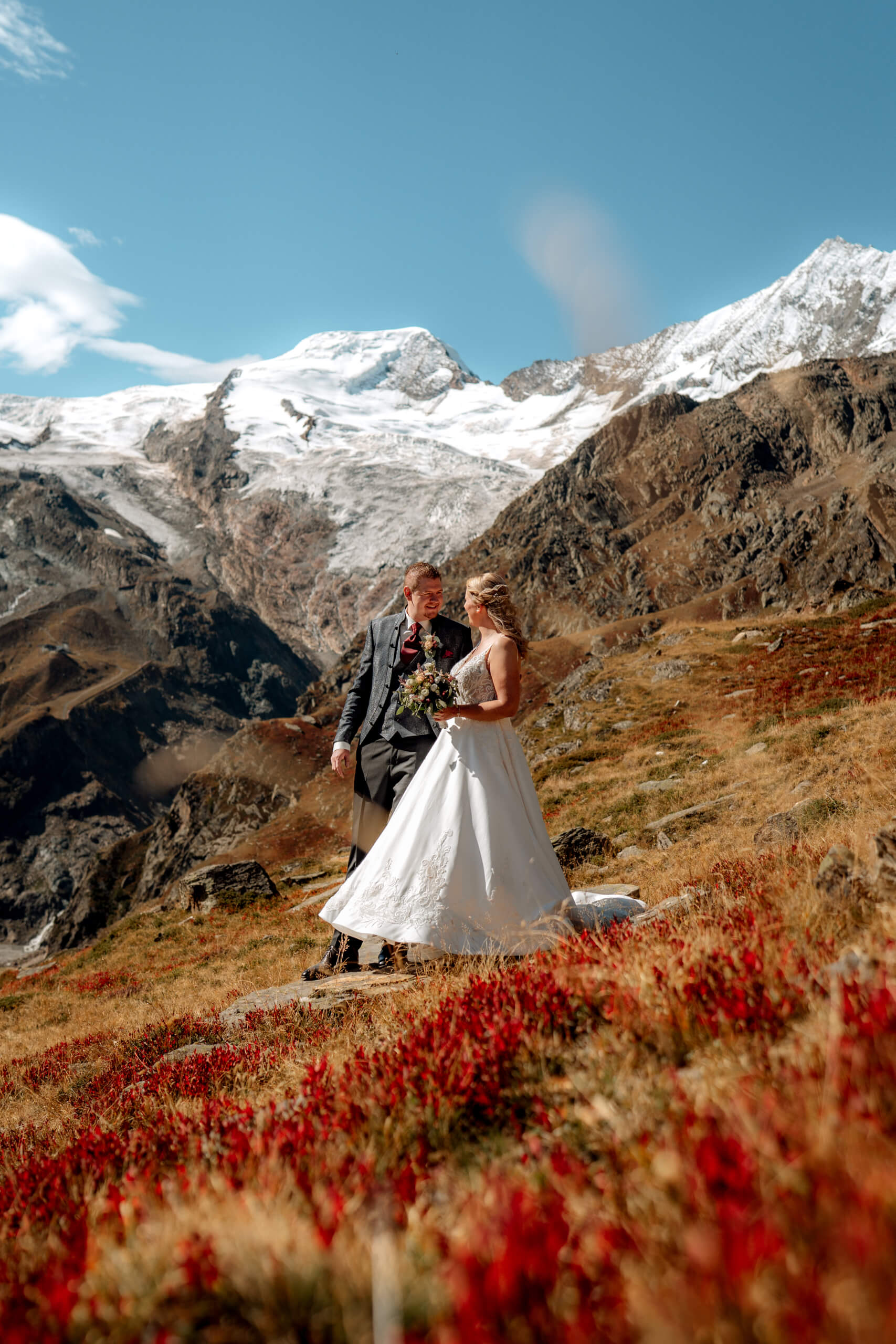 man in black suit kissing woman in white wedding dress