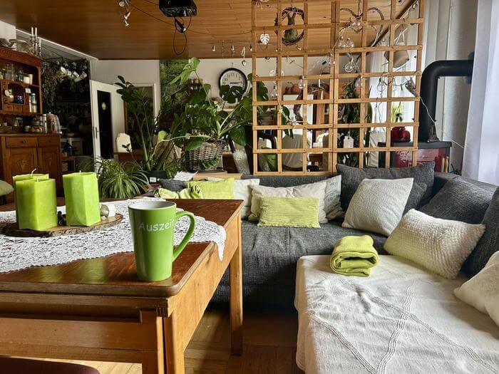 Gemütliche Sofaecke mit Kissen und einer Tasse mit der Aufschrift Auszeit