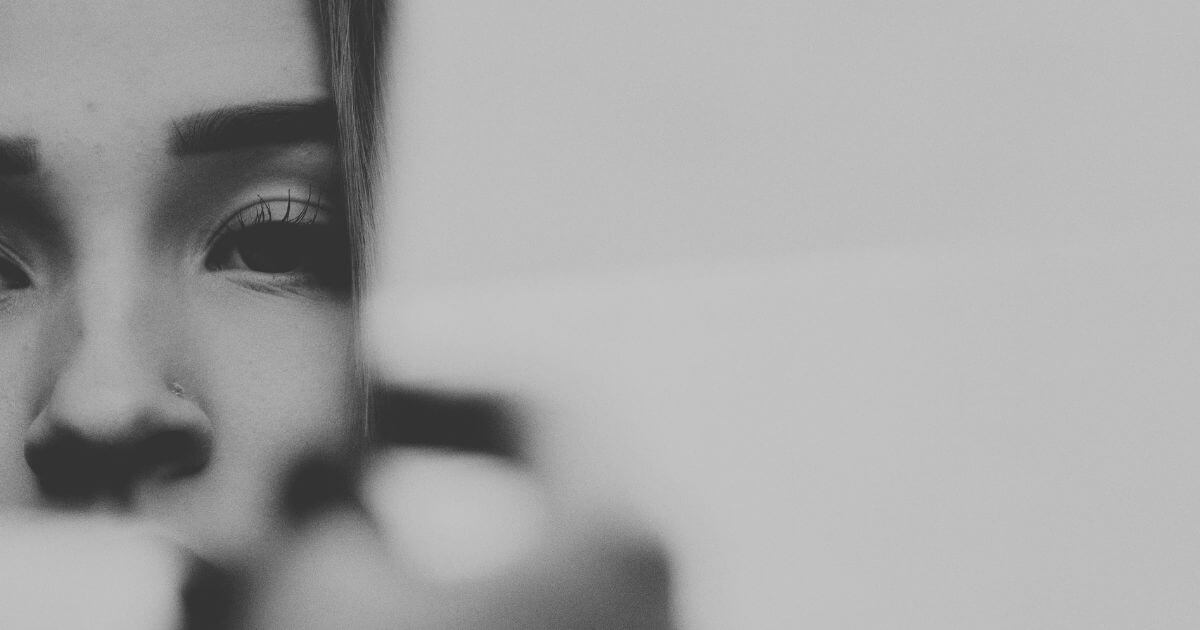 Schwarz-weiß Fotografie eines nachdenklichen Gesichts, teilweise im Unschärfebereich, als Symbol für emotionale Entfremdung und inneres Abschalten.