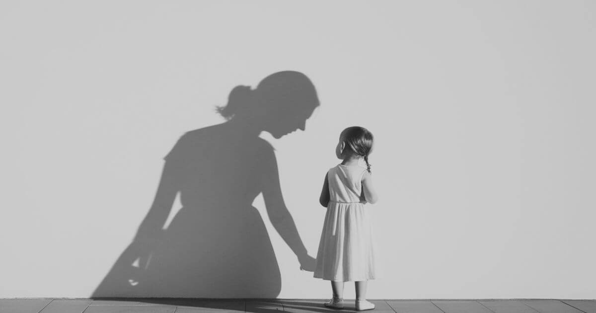 Silhouette eines Kindes, das vor dem Schatten einer erwachsenen Person steht – symbolisch für frühe Verletzungen und ihre Wirkung bis ins Erwachsenenalter.