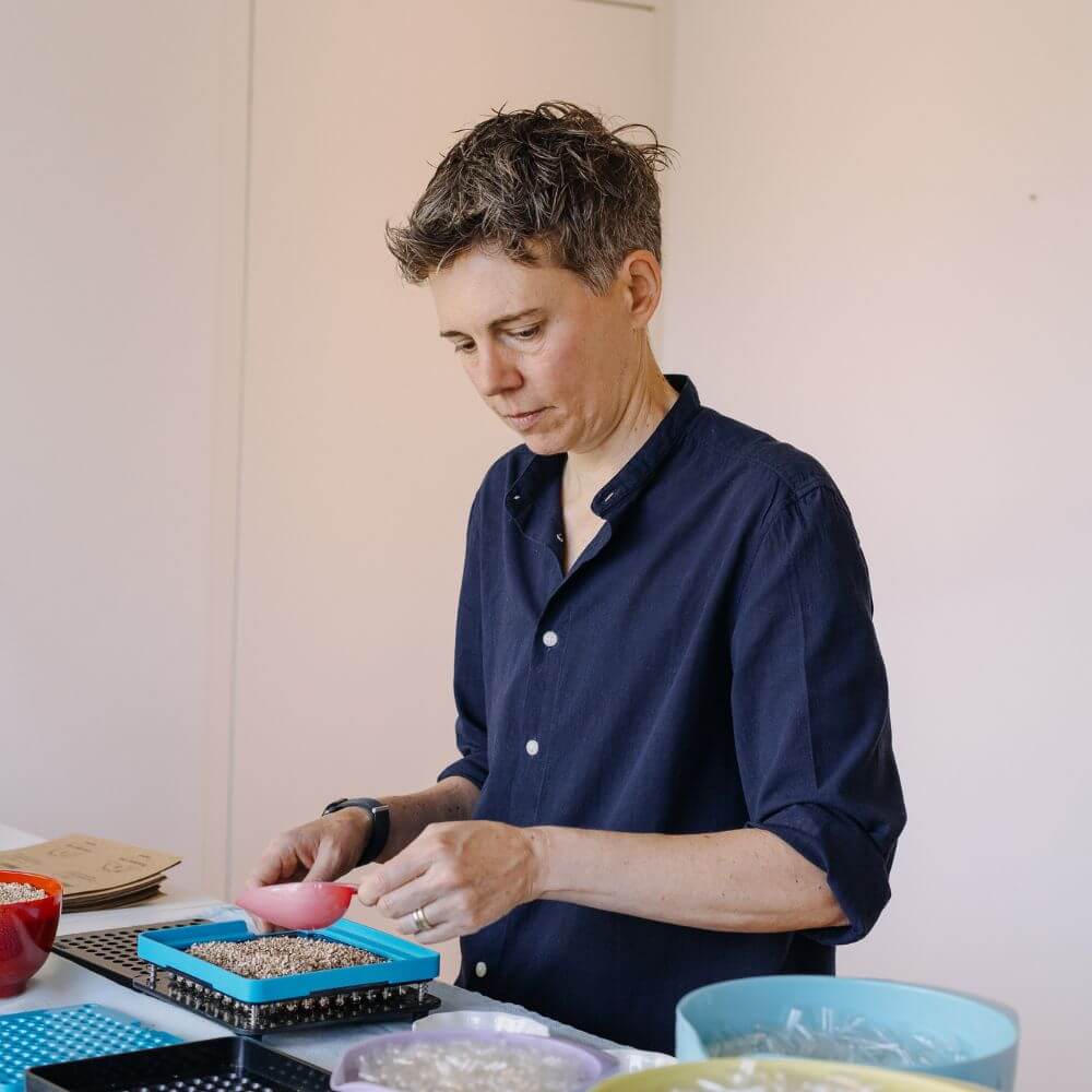 Foto von Chris Brehm bei der Herstellung der Saatgut-Kapseln