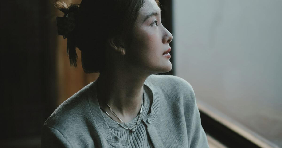 Psychische Belastung ist keine Schwäche: Person blickt ruhig aus dem Fenster als Symbol für Würde und Entstigmatisierung.